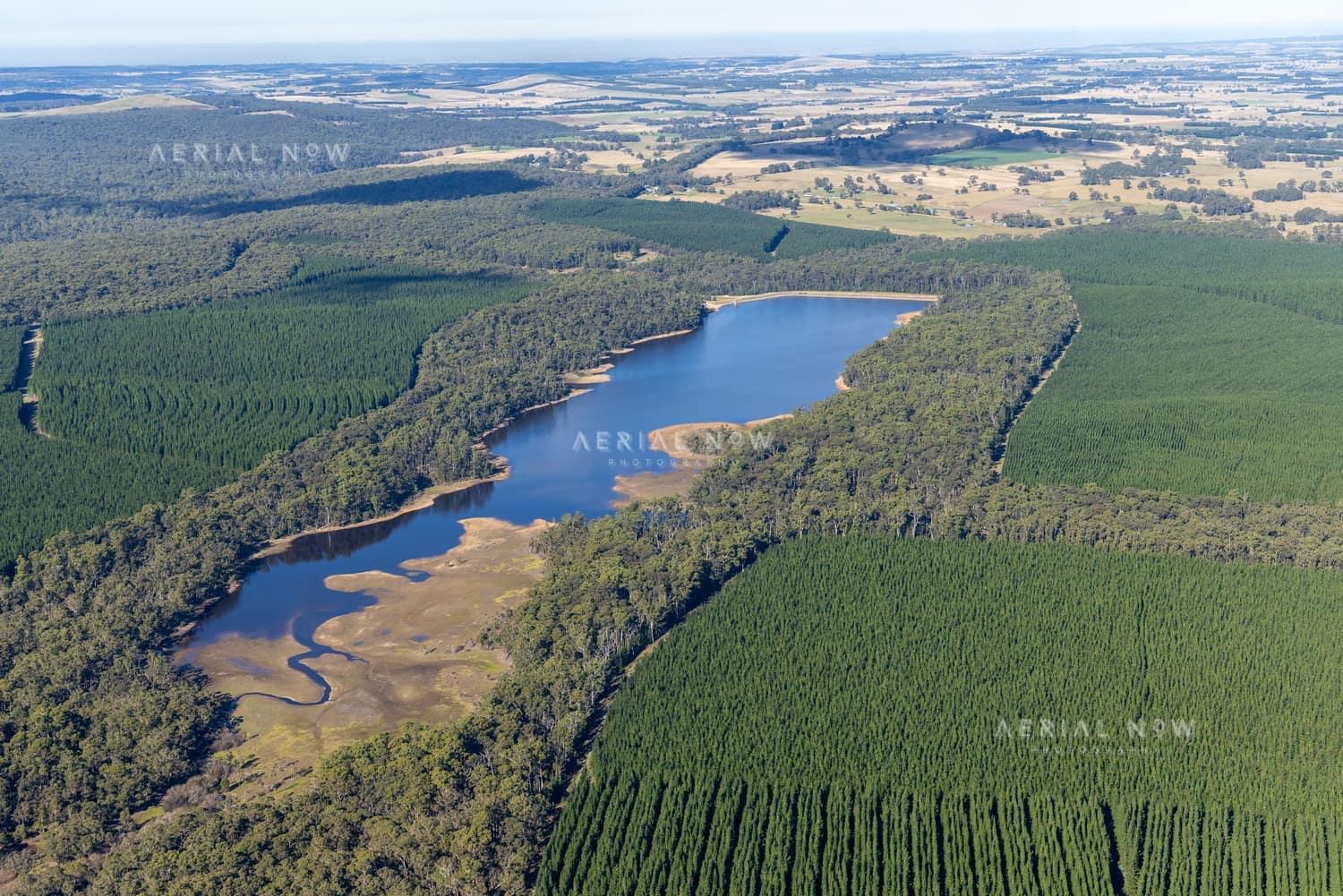 Aerial view of Bostock Reservoir at Spargo Creek, showing the forested shoreline, shallow inlet areas and surrounding pine plantations and farmland.