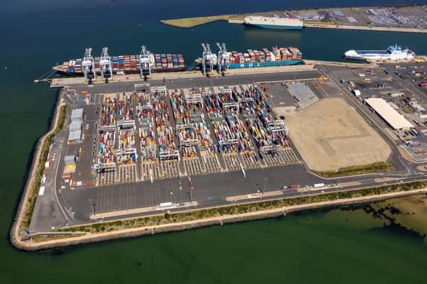 Aerial view of Webb Dock East at the Port of Melbourne in Port Melbourne, showing container stacks, ship-to-shore cranes, berthed container vessels, port roads and surrounding harbour water.