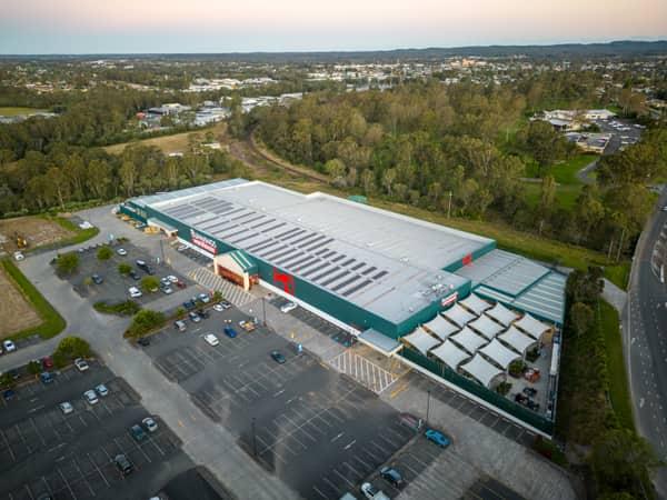 Aerial view of Bunnings Warehouse Taree on Wingham Road with car parking, surrounding trees and nearby commercial areas in Taree NSW.