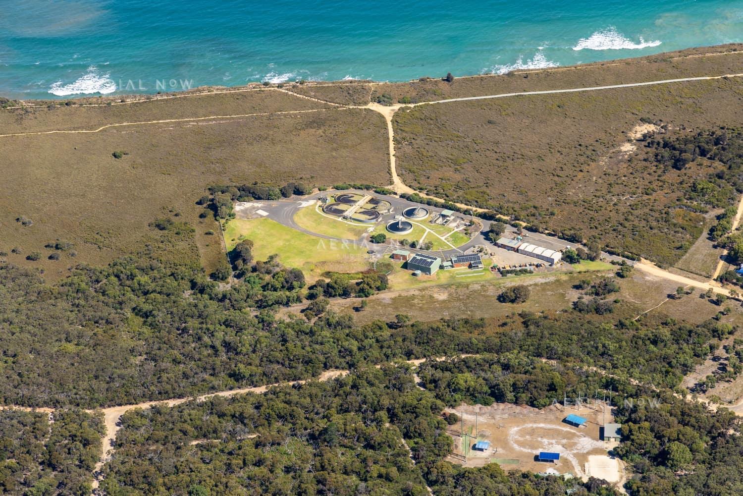 Aerial view of Anglesea Water Reclamation Plant with treatment ponds and utility buildings set among coastal vegetation near the Bass Strait shoreline in Anglesea, Victoria.