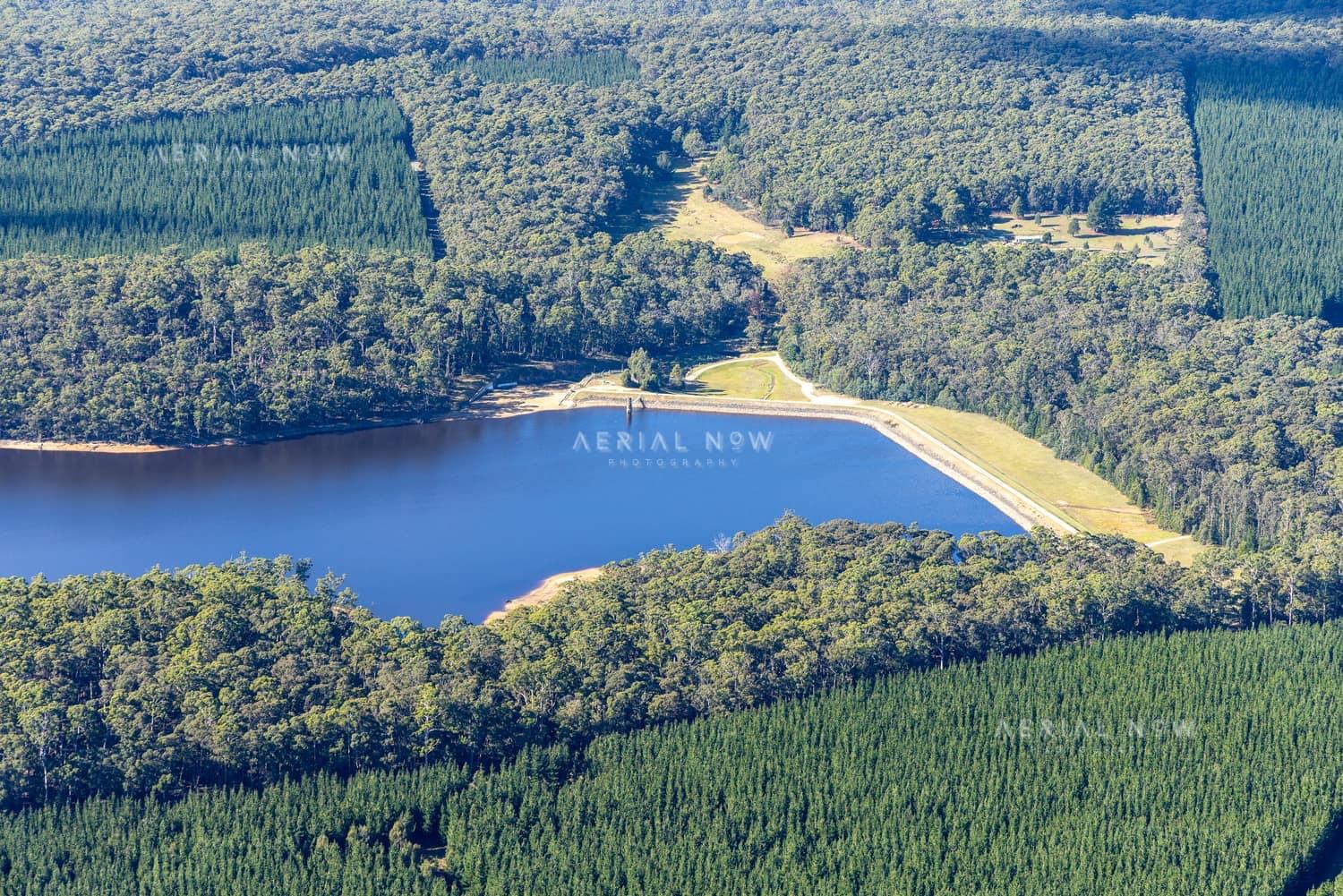 Aerial view of Bostock Reservoir at Bolwarrah, showing the dam wall, blue water storage, surrounding forest and pine plantation.