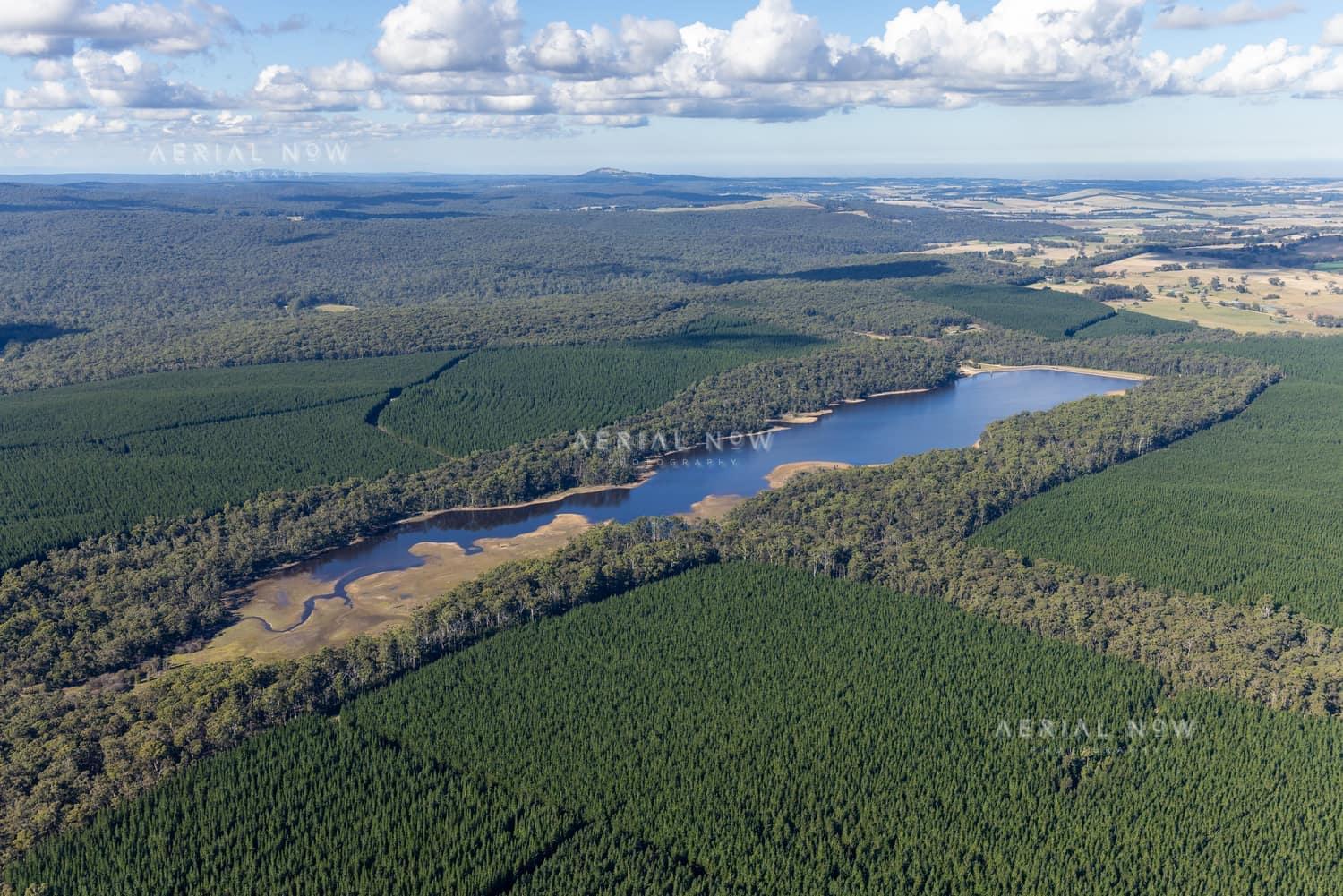 Aerial view of Bostock Reservoir near Barkstead, showing the reservoir water, exposed shallow edges, surrounding forest and plantation country.