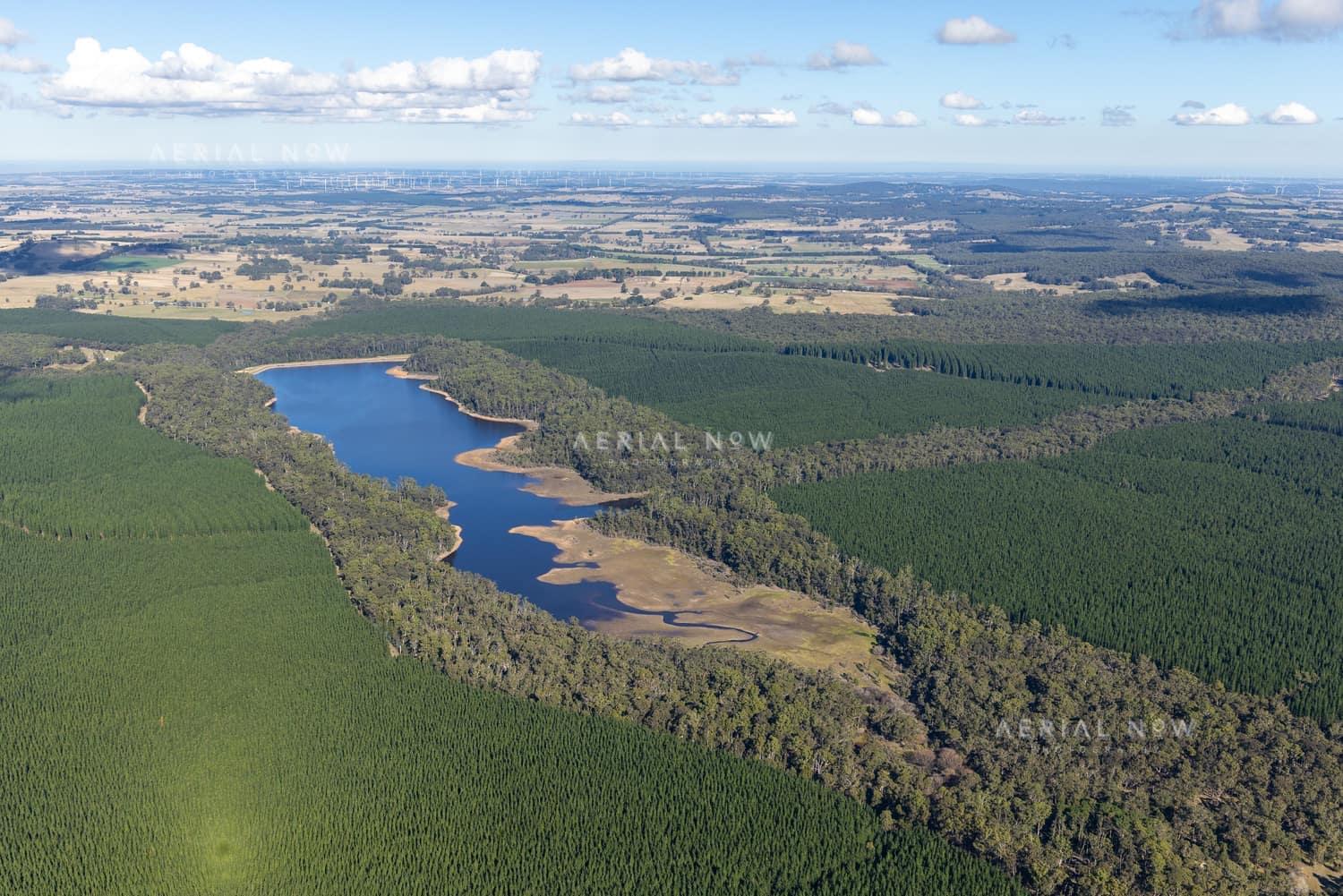 Aerial view of Bostock Reservoir at Spargo Creek VIC, showing the blue reservoir inlet bordered by forest, pine plantations and surrounding rural land.